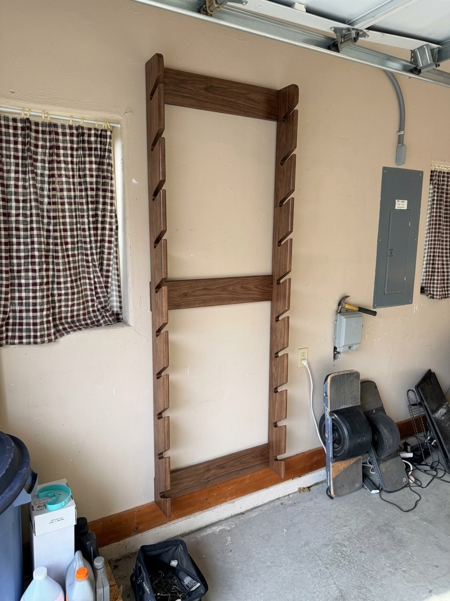 Empty walnut-stained ski rack on a garage wall showing two tall uprights with angled slots and three crossbars